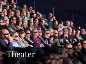 Audience wearing 3D glasses seated in a theater